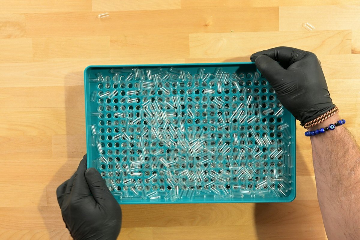 Gloved hands holding a multi-cavity silicone mould