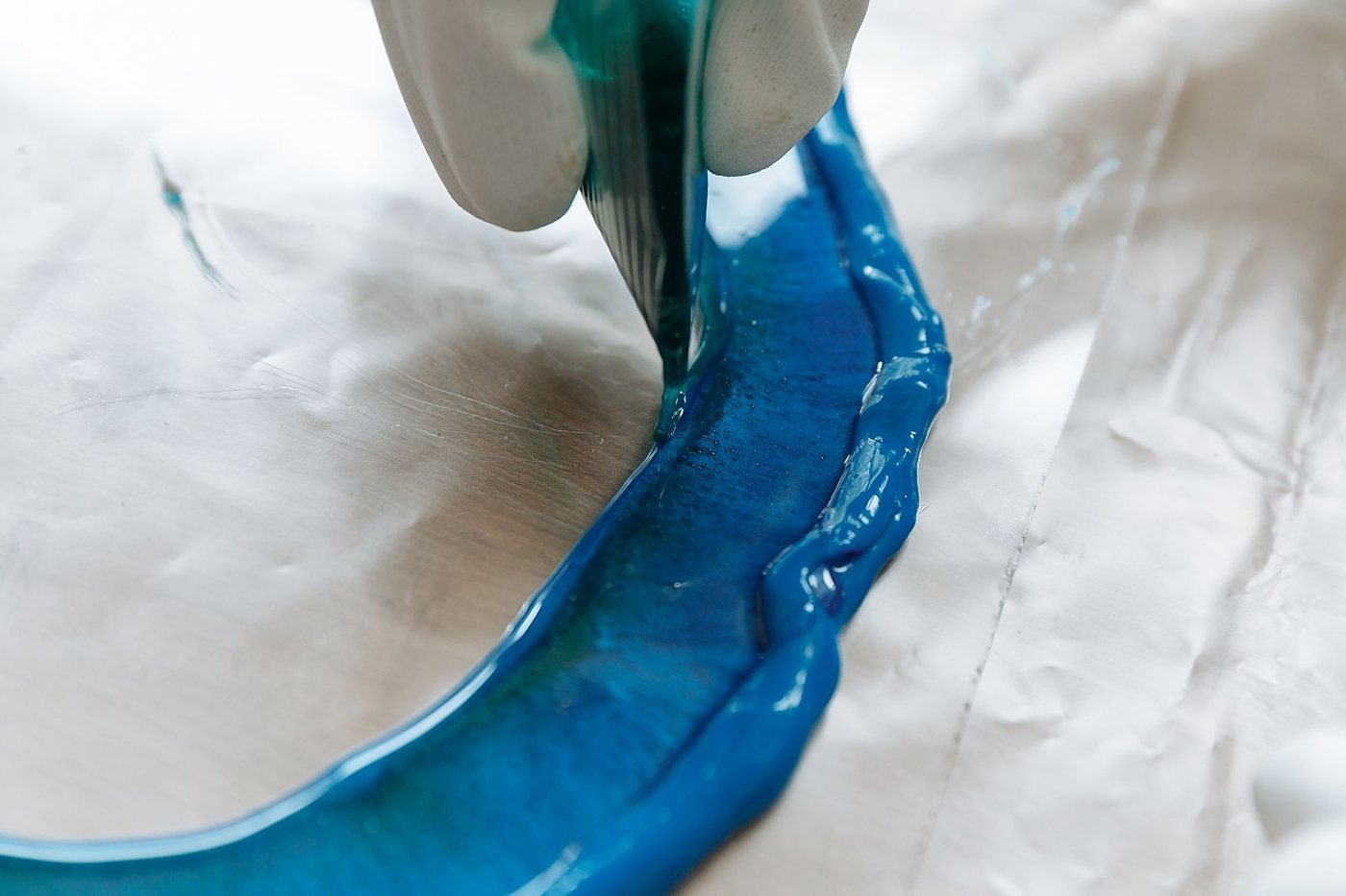 Pouring blue resin into a silicone mould